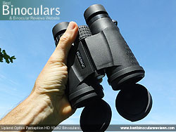 Hand holding the Upland Optics Perception HD 10x42 Binoculars